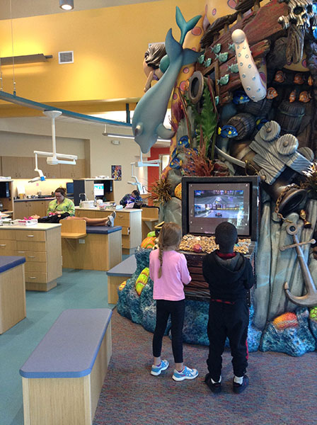Children exploring the giant shipwreck sculpture in the Fort Myers office