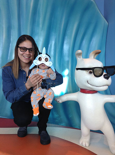 Shades the mascot dog statue posing with a mom and baby